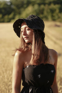 Woman wearing hat standing on field