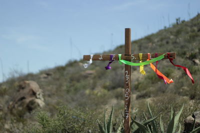 Close-up of cross on field against sky