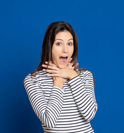 Portrait of beautiful young woman against blue background