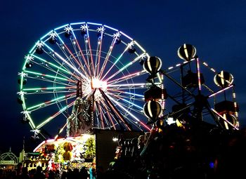 Low angle view of illuminated ferris wheel against sky at night