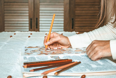 Close-up of woman hand holding paper on table