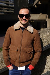 Portrait of young man wearing sunglasses standing outdoors