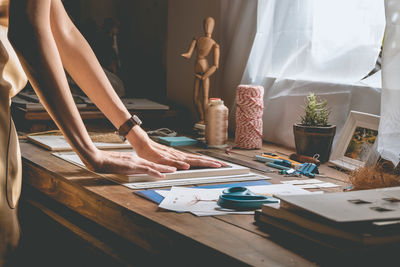 Low section of woman standing on table