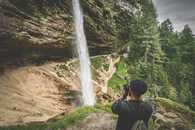 Rear view of woman looking at waterfall