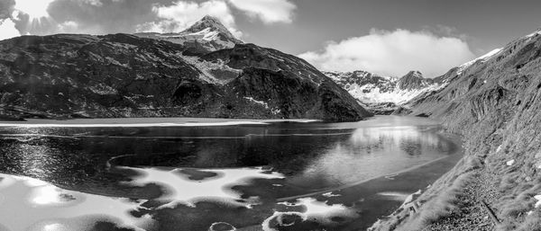 Scenic view of lake and snowcapped mountains against sky