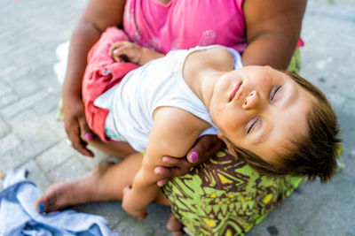 Low section of woman with son begging on footpath