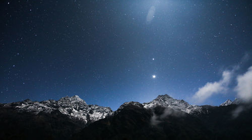 Low angle view of mountains against sky at night