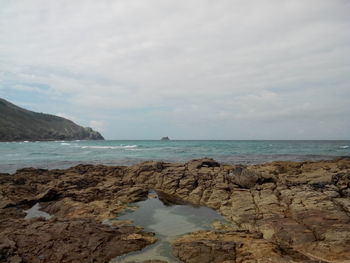 Scenic view of sea against cloudy sky