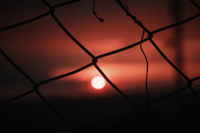 Close-up of silhouette fence against sky during sunset