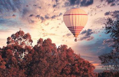 Digital composite image of hot air balloons against sky during sunset