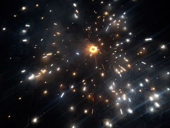 Low angle view of fireworks against sky at night