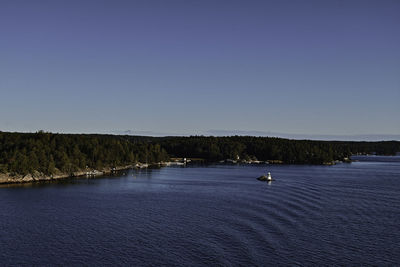 Scenic view of lake against clear blue sky