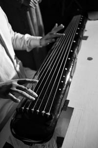 Midsection of man playing string instrument