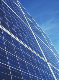 Low angle view of rainbow against blue sky