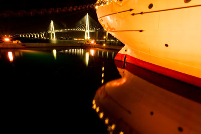 Illuminated bridge over river at night