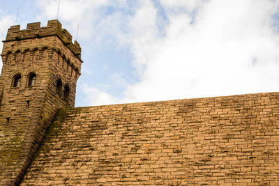 Low angle view of fort against cloudy sky