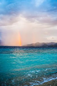 Scenic view of rainbow over sea against sky