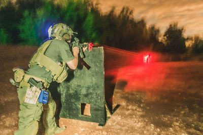 Rear view of man holding umbrella on road