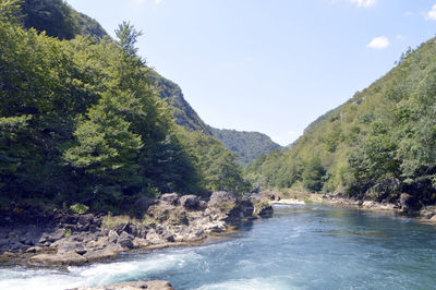 Scenic view of river and mountains against sky