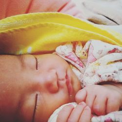 Close-up of baby hand on bed