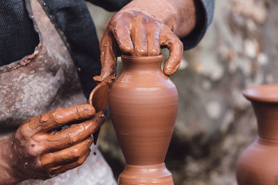 Close-up of hands working in mud