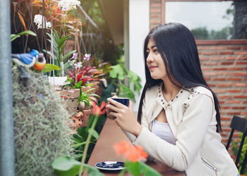 Woman looking at camera while using mobile phone