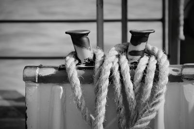 Close-up of rope tied on metal against wall