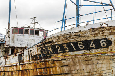 Low angle view of abandoned ship against sky