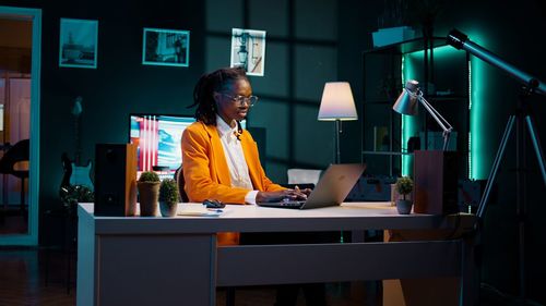 Portrait of young woman using mobile phone while sitting on table