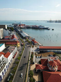 High angle view of city by sea against sky