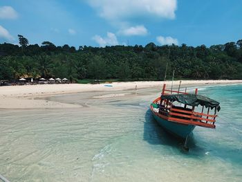 Boat moored on shore against sky