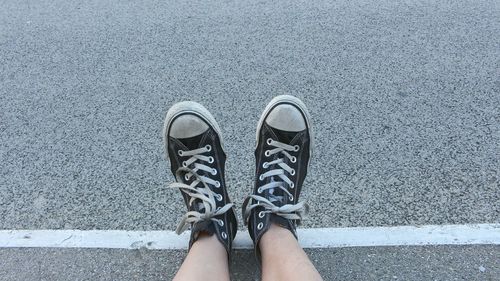 Low section of woman standing on road