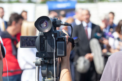 Cropped hand of person recording people in press conference