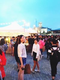 People looking at town in front of sky