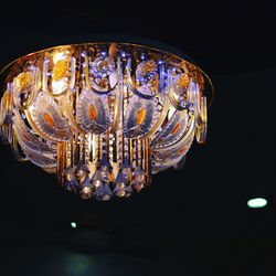 Low angle view of illuminated light bulb against black background