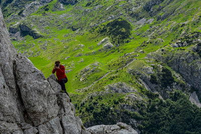 Man standing on rock by mountain