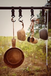 Close-up of cooking pots hanging on pole