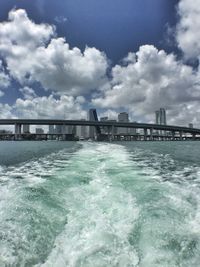 Bridge over river against cloudy sky