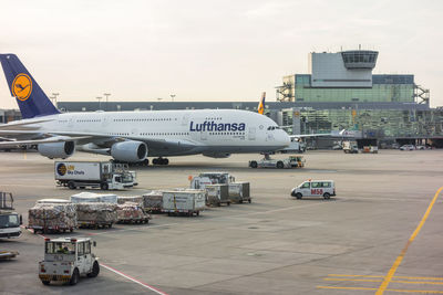 Airplane on airport runway against sky