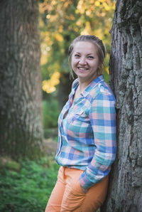 Portrait of young woman standing in forest