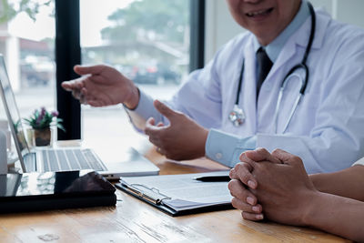 Midsection of man using laptop on table