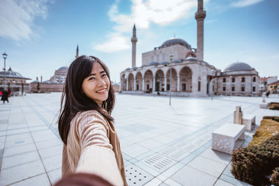 Portrait of smiling young woman sitting on terrace