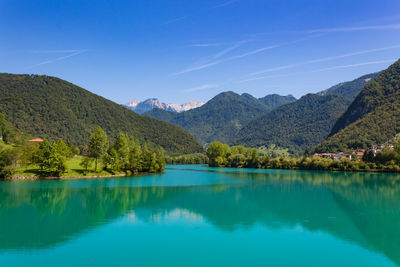 Scenic view of lake and mountains against blue sky