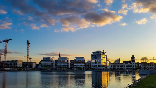 Buildings at waterfront during sunset