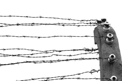 Low angle view of barbed wire against clear sky