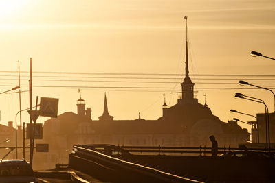 Low angle view of people on street against sky during sunset