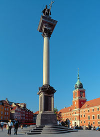 Statue of fountain in city against blue sky