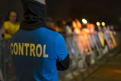 Rear view of man standing on street in city at night