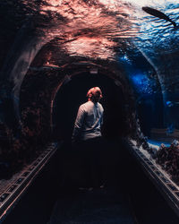 Rear view of man standing in tunnel