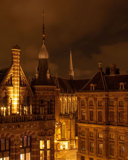 Illuminated buildings in city against sky at night